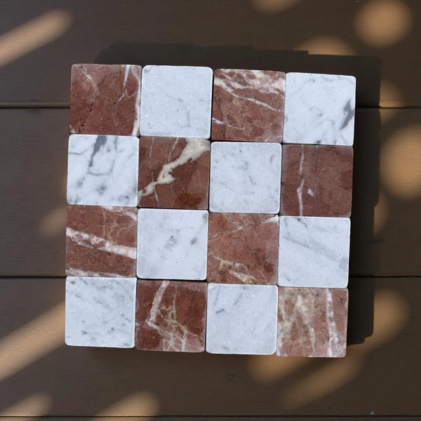 Checkerboard pattern of Carrara White and Rojo Alicante 3x3 marble tiles with natural veining