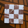 Checkerboard pattern of brown and white marble tiles from Carrara White and Rojo Alicante