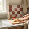 A rustic ceramic oil dispenser with a slender neck and matte off-white finish featured alongside checkerboard carrara white rojo alicante 3x3 tumbled tiles