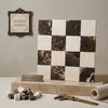 A checkerboard pattern of spanish marble tiles alternating crema marfil white and emperador dark brown with natural veining