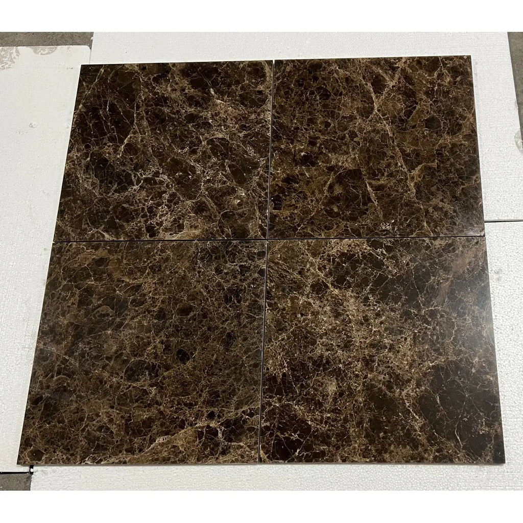 Four square brown Emperador Dark marble tiles with golden veining