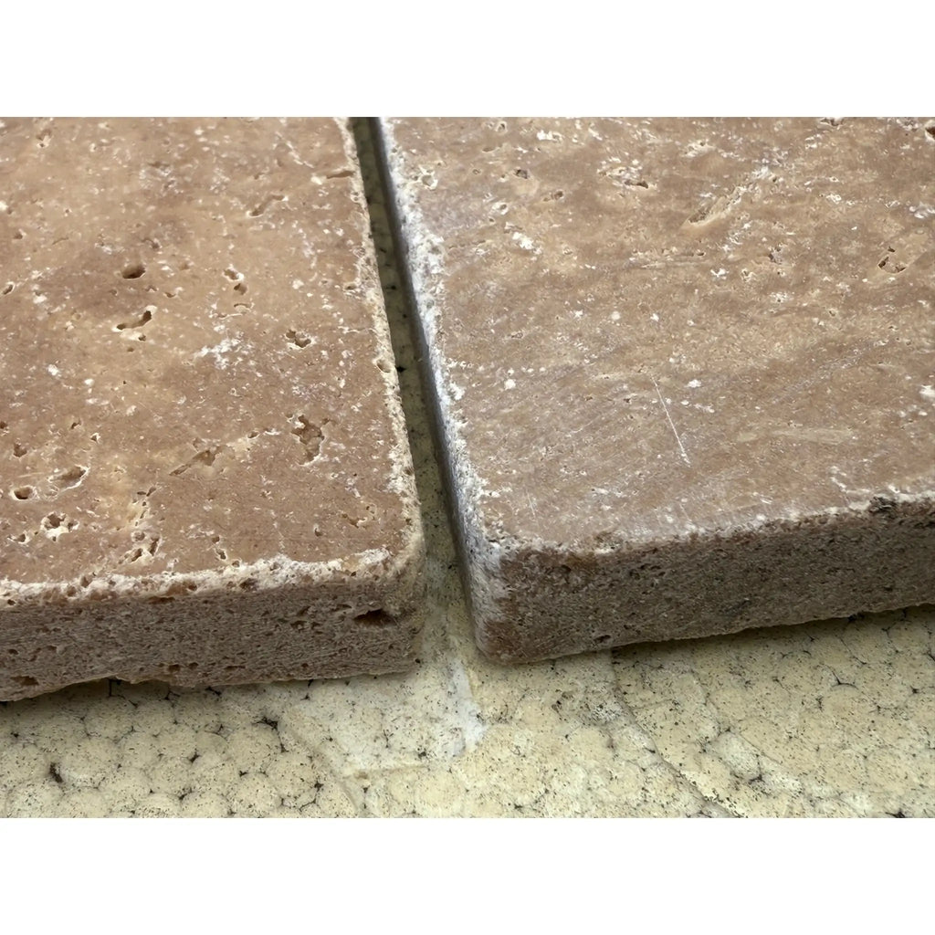 Two porous brown travertine tiles from Checkerboard Ivory and Noce Tumbled set