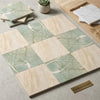 Square tiles set featuring checkerboard ming green and diano royal marble in soft green and beige tones with elegant veining