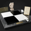 Checkerboard nero marquina black and white marble tiles 12x12 set displayed on dark gray marble base