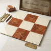 A square checkerboard rodo alicante and crema marfil marble tile panel with terracotta and creamy white veined blocks