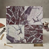 Four square marble tiles in checkerboard rosso levanto and calacatta viola imperiale with deep burgundy and soft gray hues