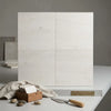 Four square off-white marble effect crema haven 12x12 limestone tiles with subtle veining arranged in a grid