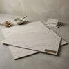 Crema haven 18x36 limestone floor tiles in light gray marble effect with subtle veining and matte finish in overlapping stacks