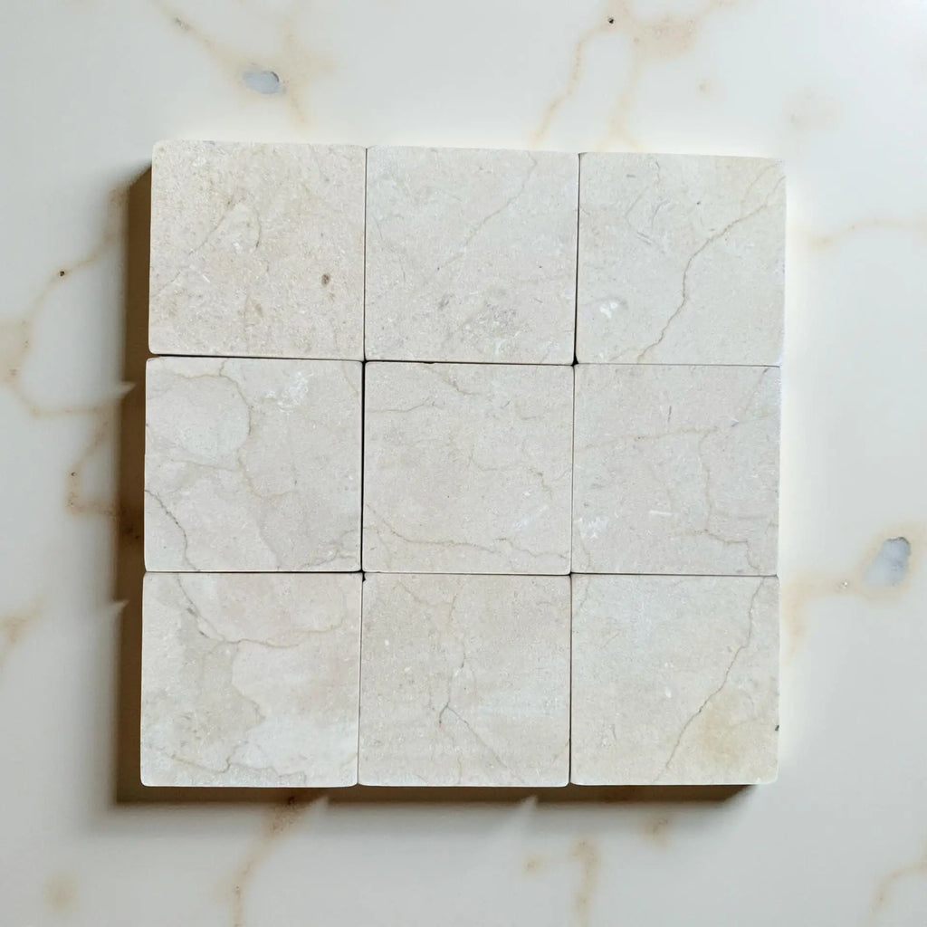 Crema Marfil 4X4 Tumbled marble tiles with subtle veining in a grid layout