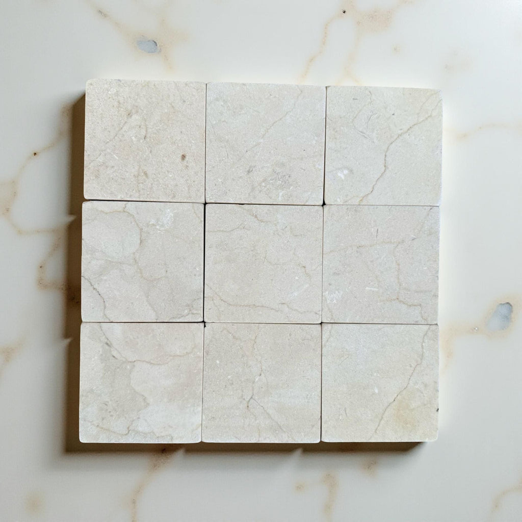 Crema Marfil 4X4 Tumbled marble tiles with subtle veining in a grid layout