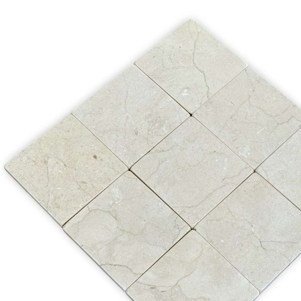 Light-colored square marble tiles with natural veining in Crema Marfil 4X4 Tumbled product