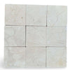 Light beige Crema Marfil 4x4 tumbled marble tiles with subtle veining patterns