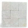 Light beige Crema Marfil 4x4 tumbled marble tiles with subtle veining patterns