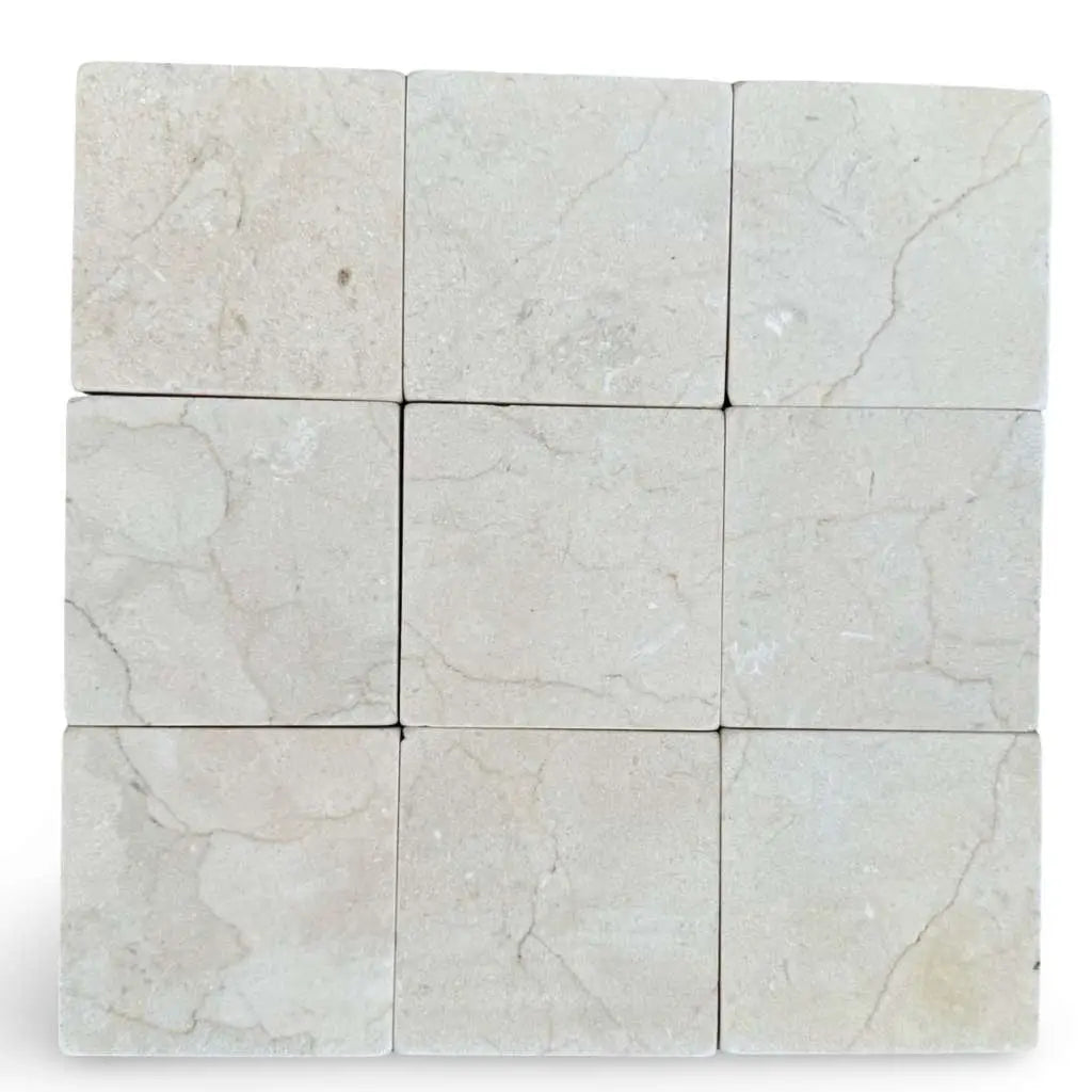 Light beige Crema Marfil 4x4 tumbled marble tiles with subtle veining patterns