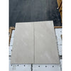 Two rectangular light-colored Crema Marfil marble tiles showcasing polished or honed finish
