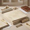 Stack of cream-colored crema marfil marble tiles with subtle veining and polished finish in 18x18 size