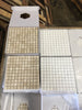 Crema Marfil marble 1x1 mosaic tiles in white and beige grid pattern, boxed with hexagonal cutouts