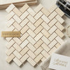 Crema marfil beige spanish marble tiles arranged in a polished herringbone mosaic pattern for flooring or walls