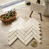 Beige crema marfil marble 1x4 polished or honed tiles arranged in a herringbone mosaic pattern