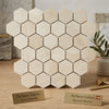 Hexagonal Crema Marfil marble mosaic tiles with a creamy beige base and subtle natural veining in polished or honed finish