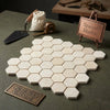 Crema marfil marble 2 inch hexagon mosaic tumbled tiles in light cream with subtle veining arranged in honeycomb pattern