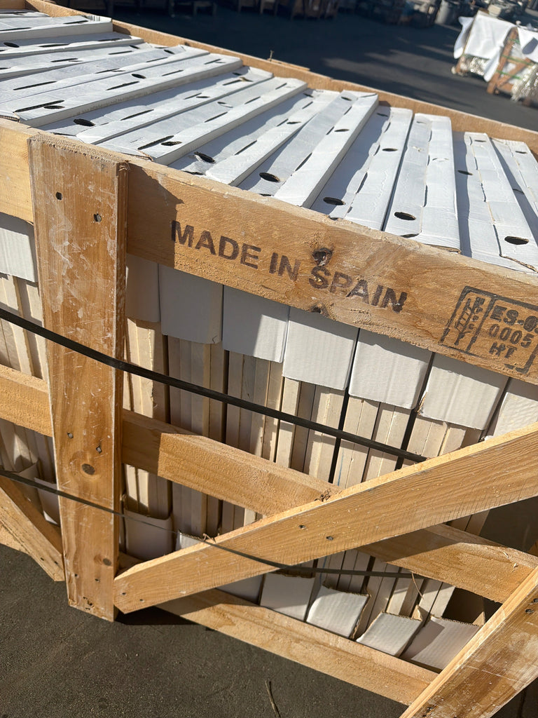 Rustic wooden crate stamped Made in Spain holds stacked Crema Marfil Marble 24x24 panels