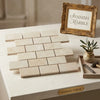 Beige crema marfil marble 2x4 brick mosaic tumbled tiles arranged in a classic brick pattern