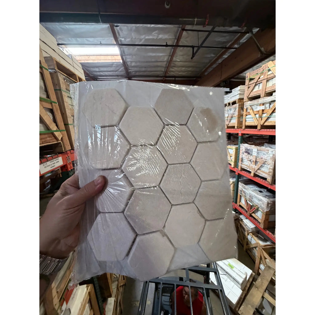 Crema Marfil Marble 3-inch hexagon mosaic tumbled tile panel in clear plastic