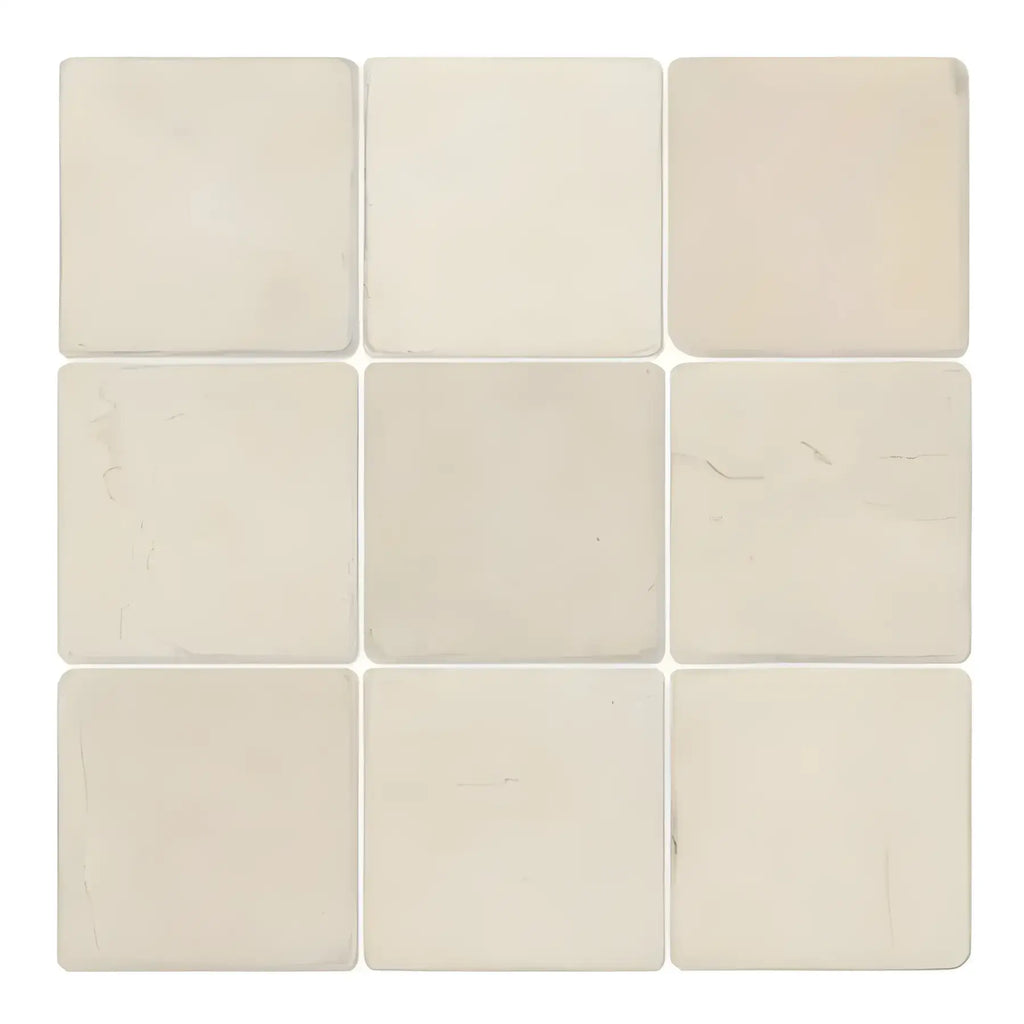 Nine off-white Crema Marfil Marble 4X4 Tumbled tiles arranged in a square pattern