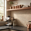 Silver espresso machine with sleek modern design and multiple control knobs displayed on crema marfil marble mini-brick mosaic