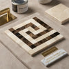 A square crema marfil marble mosaic tile panel with a polished greek key border in cream dark brown and black colors