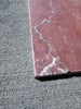 Crema Marrfil Rustic Modern Tumbled reddish-pink marble tile with white veining on gray concrete