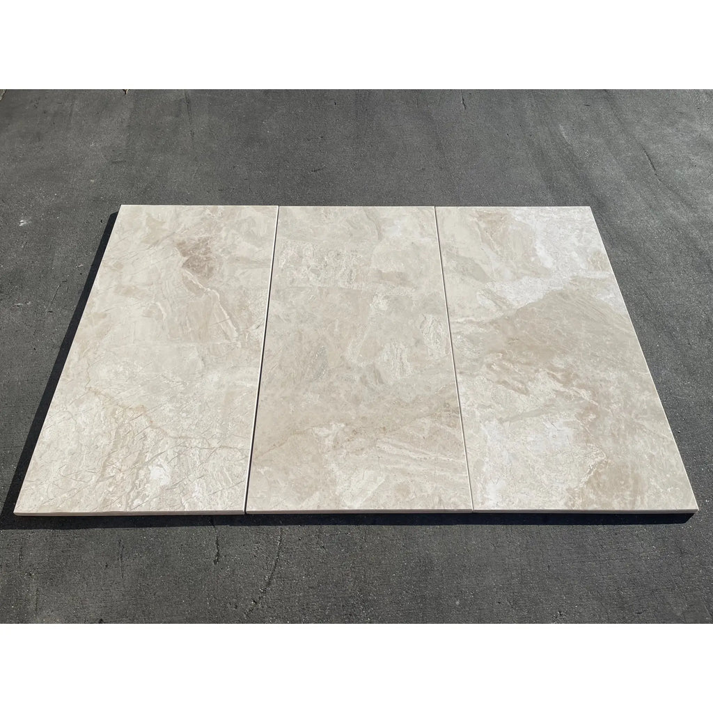 Three beige diano royal queen beige marble 12x24 polished tiles with subtle veining on a dark surface