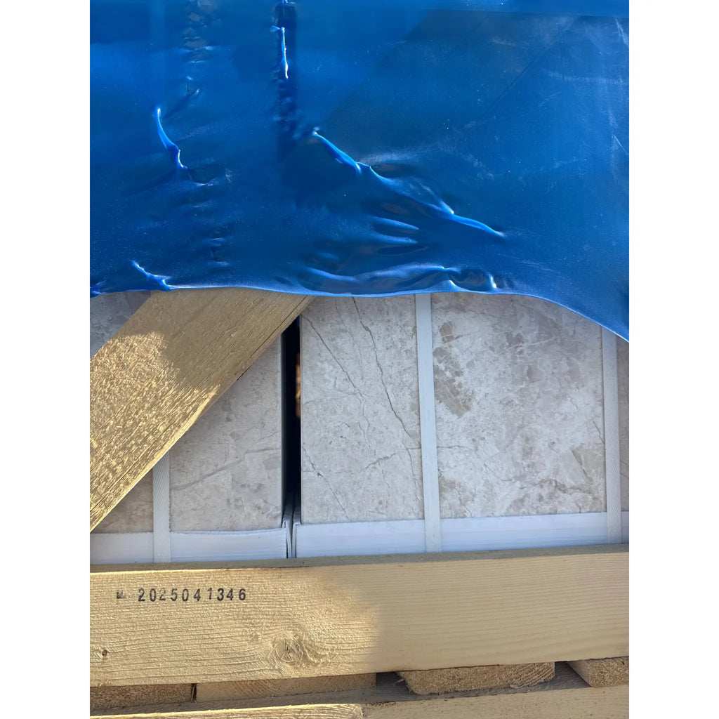 Crated Diano Royal Queen Beige Marble 12x24 tiles covered with blue plastic sheeting
