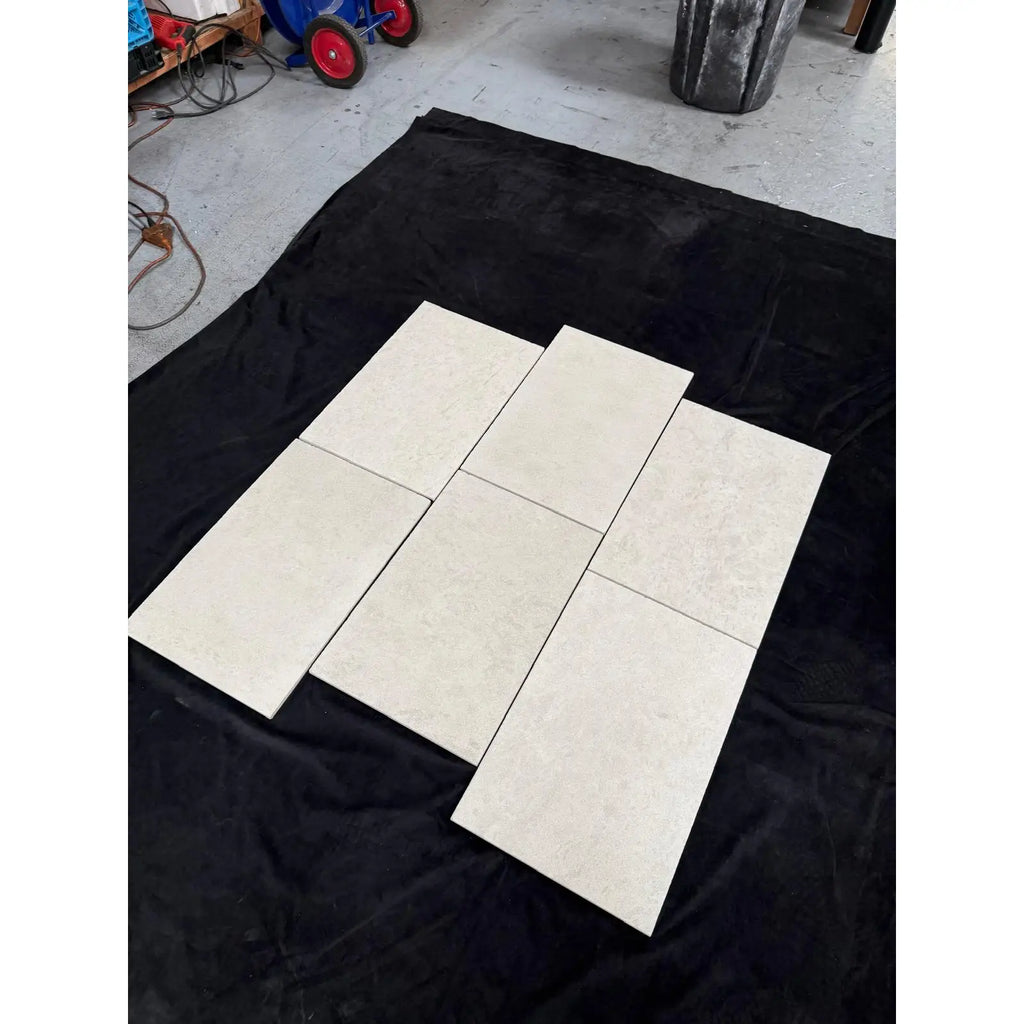 Six Dolce Crema 12X12 Limestone beige marbled tiles on black fabric