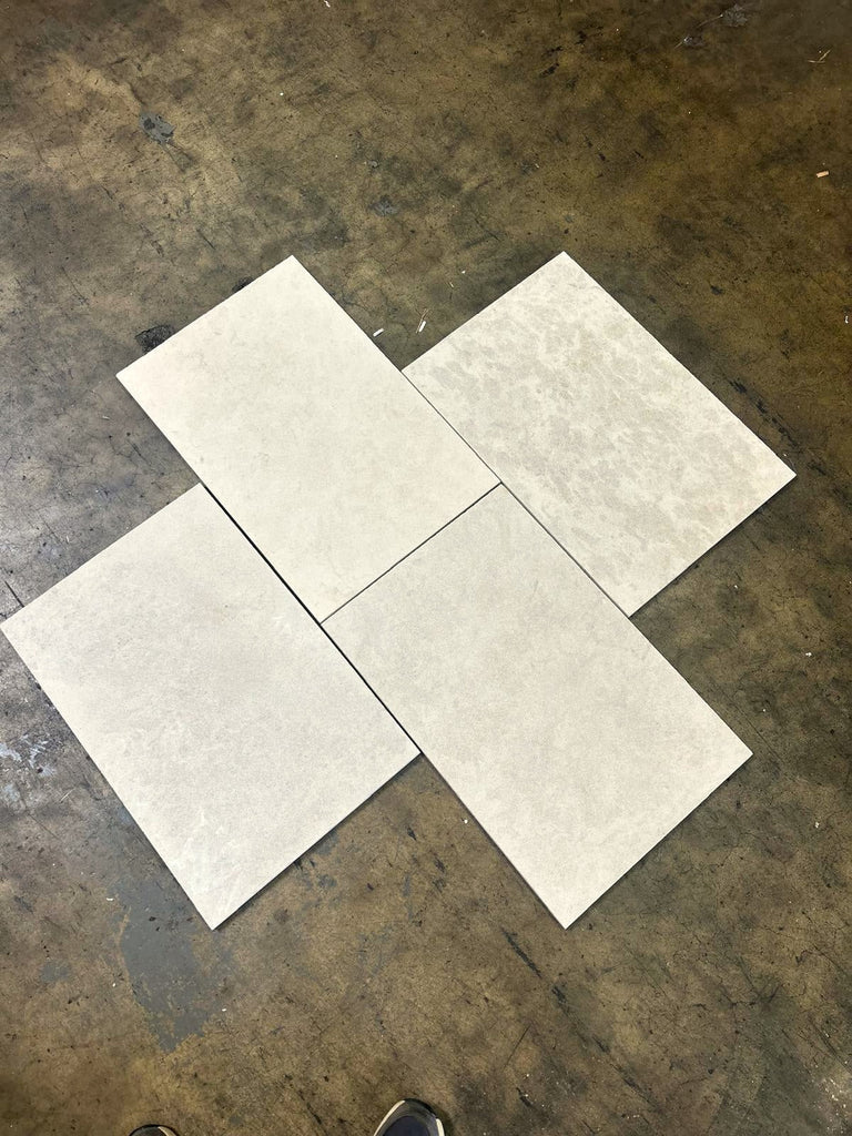 Dolce Crema 18X18 limestone: four overlapping light gray marbled tiles