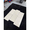 Six Dolce Crema 18X18 Limestone tiles with marbled texture on black fabric