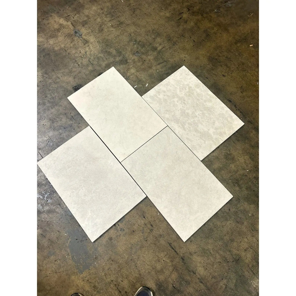 Dolce Crema 18X36 limestone: four overlapping light gray marbled tiles