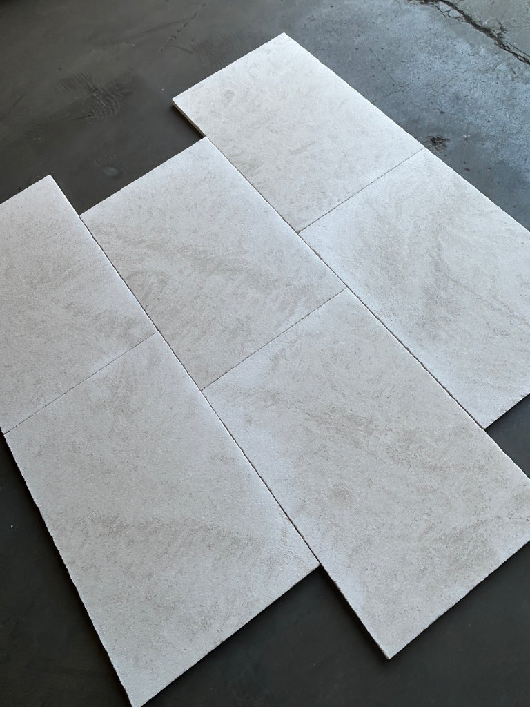 Dolce Ivory 18x36 limestone tiles in light gray with natural stone veining