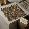 A diamond-shaped arrangement of polished emperador dark marble 1x2 mosaic tiles in brown and beige with natural veining
