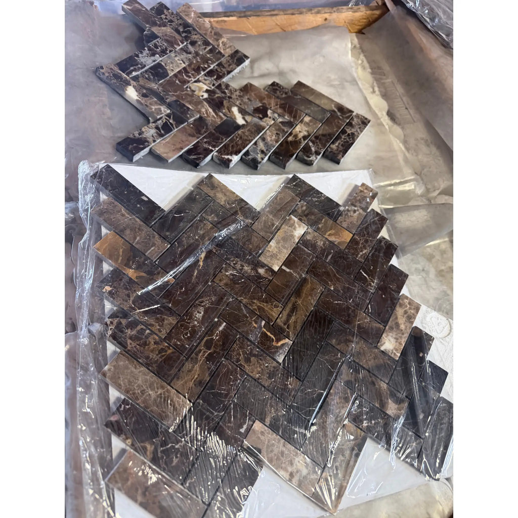 Dark brown emperador marble 1x3 herringbone mosaic tiles with swirling veining wrapped in clear plastic