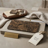 A rectangular spanish marble cutting board with rich brown and black veined emperador dark marble 3x6 tumbled design