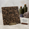 A square emperador dark marble 5/8x5/8 mosaic tumbled tile panel with dark brown and gold veining on a brass stand