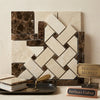 A polished emperador dark marble basketweave border corner with crema marfil dots in a cream and dark brown herringbone mosaic pattern