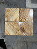 Four polished Golden Horizon Marble 12x12 tiles with brown and beige veining