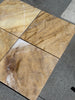 Four polished Golden Horizon Marble 12x12 tiles with natural brown and white veining