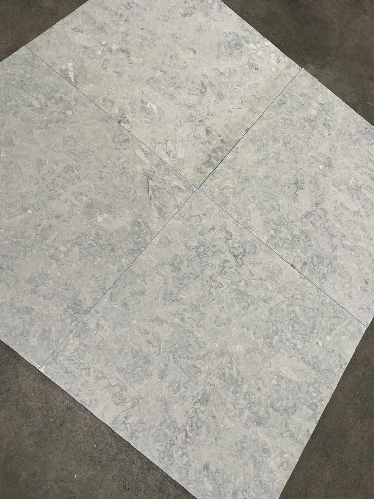 Greyhaven 12x24 limestone honed tiles with gray marble-effect veining and polished finish