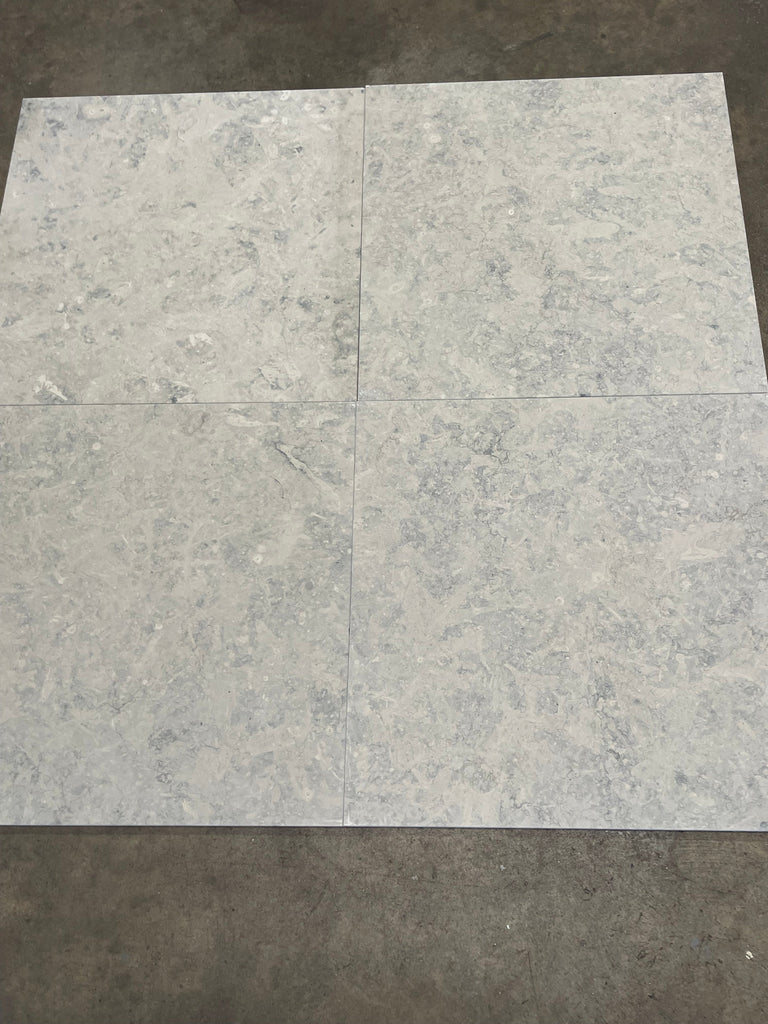 Four Greyhaven 24x24 honed limestone tiles in gray marble-effect grid