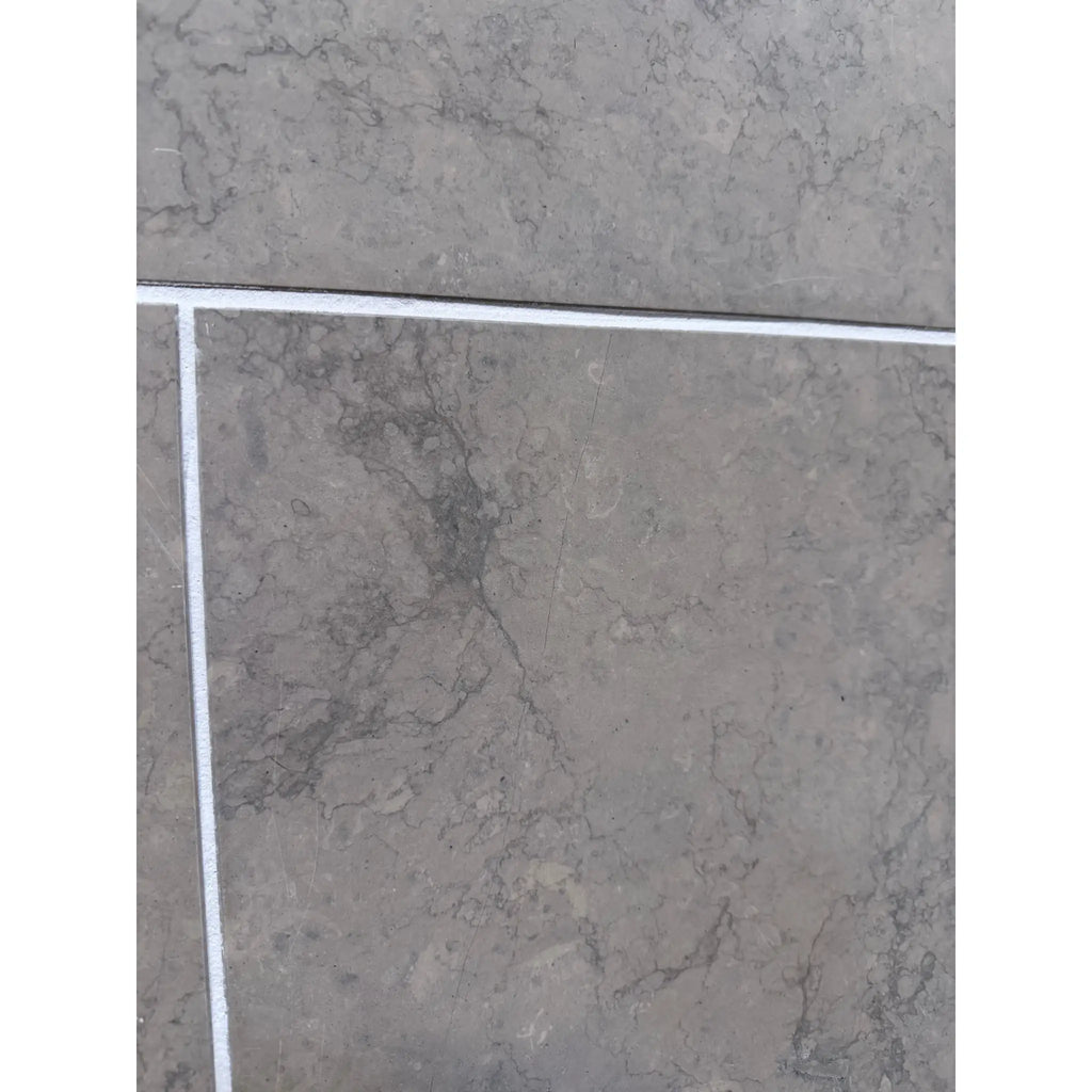 Greyhaven 24x24 honed limestone tile with gray marble veining and white grout