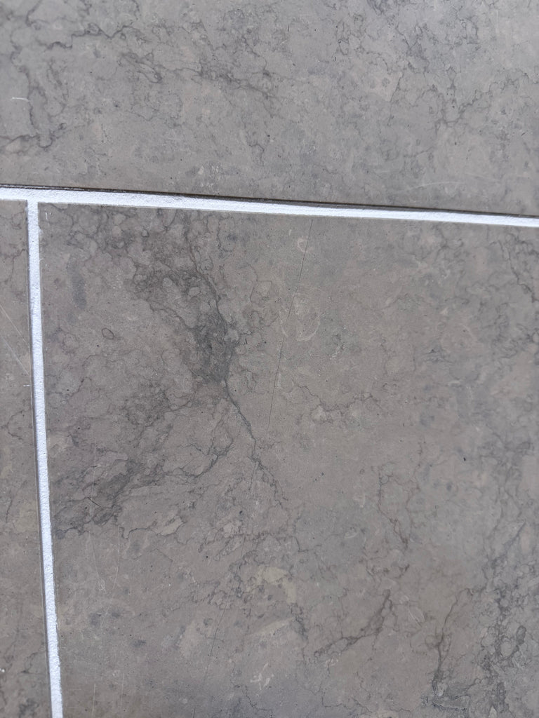 Greyhaven 24x24 honed limestone tile with gray marble veining and white grout